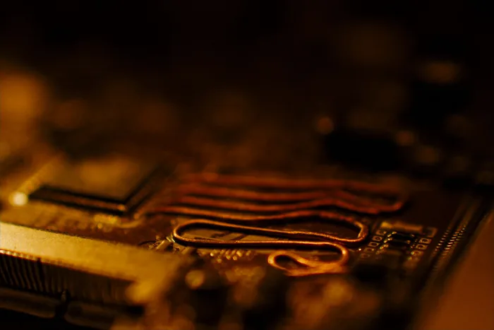 An extreme close-up of a circuit board, copper traces and components in shallow focus.