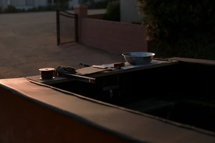 An open truck tailgate used as a workbench in a driveway.