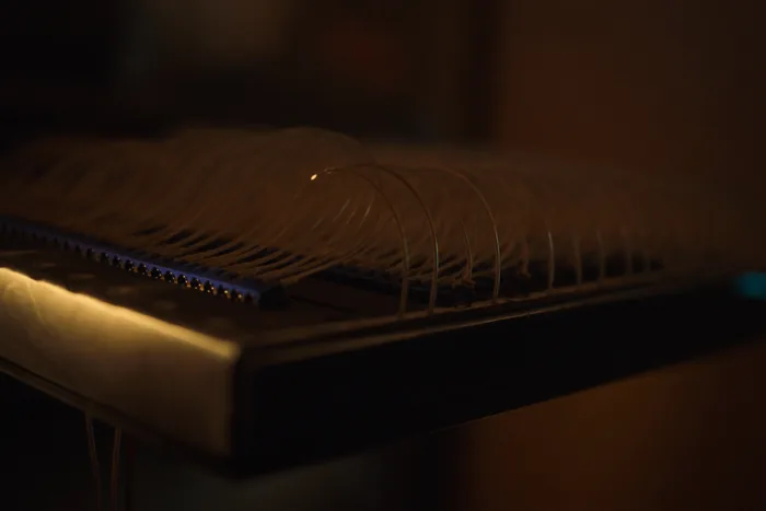 A fibre patch panel with cables fanned across it, amber light catching the ferrules.