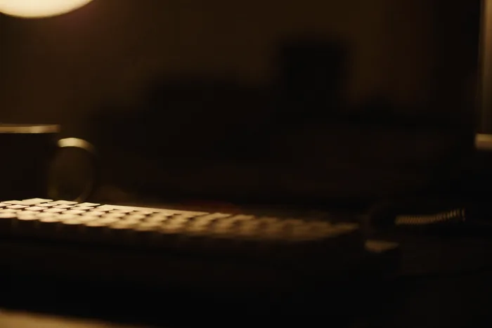 A mechanical keyboard lit only by screen glow in a dark room.
