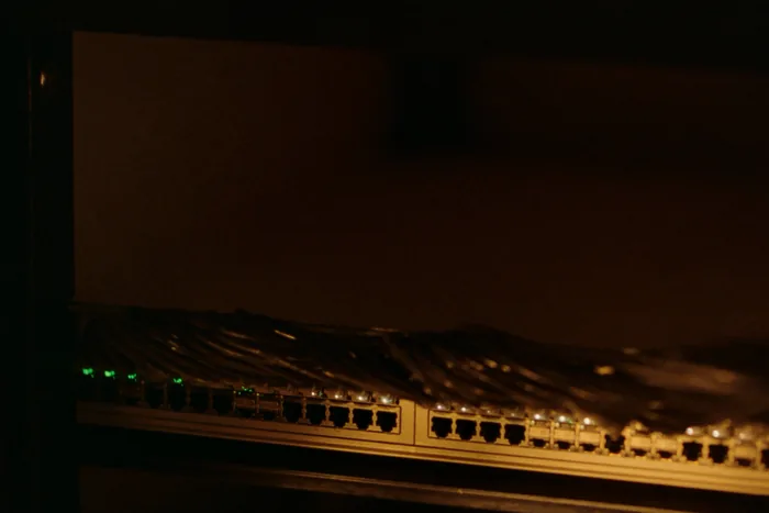 A managed network switch with patch cables seated in its ports, link lights showing.